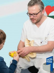 Pfleger gibt jungem Patienten einen Keks