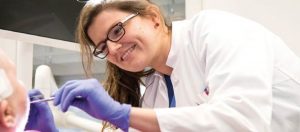 Ärztin untersucht Mundraum eines Patienten