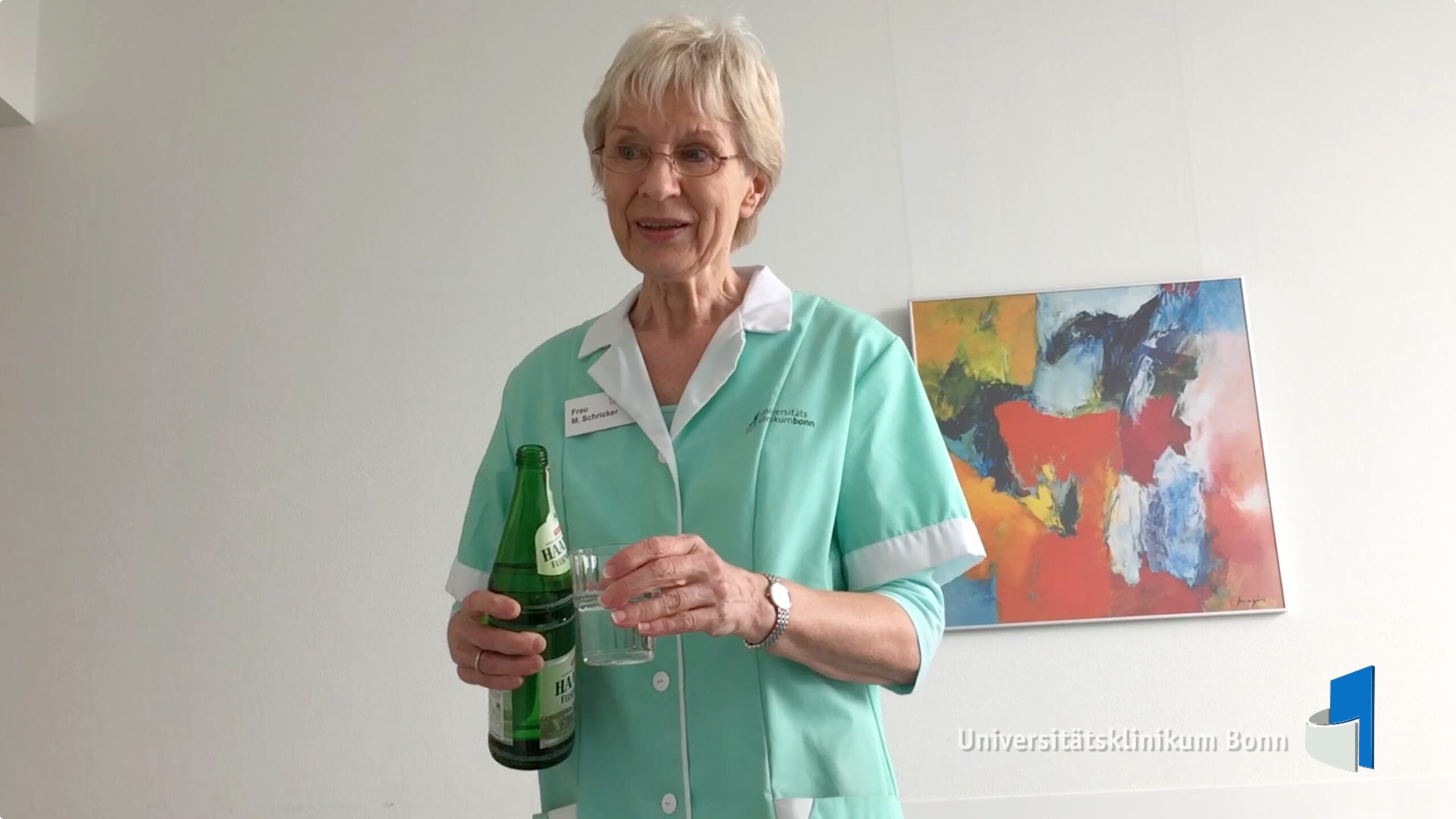 Grüne Dame schenkt Wasser in Glas