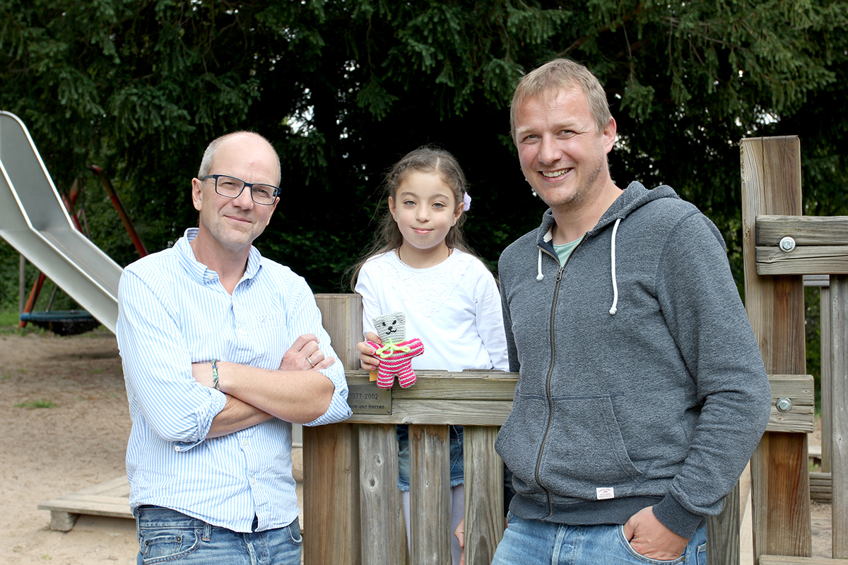 Prof. Dr. Bernd Hoppe und Dr. Markus Feldkötter mit syrischem Flüchtlingskind