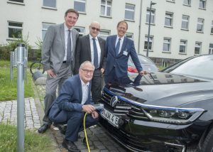 Der Fahrer des Universitätsklinikums Bonn Karl-Heinz Lohmer lädt den neuen Elektro- Dienstwagen des Uniklinikums Bonn. Die Vorstandmitglieder Prof. Wolfgang Holzgreve, Damian Grüttner und Alexander Pröbstl freuen sich