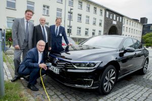 Der Fahrer des Universitätsklinikums Bonn Karl-Heinz Lohmer lädt den neuen Elektro- Dienstwagen des Uniklinikums Bonn. Die Vorstandmitglieder Prof. Wolfgang Holzgreve, Damian Grüttner und Alexander Pröbstl freuen sich