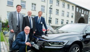 Der Fahrer des Universitätsklinikums Bonn Karl-Heinz Lohmer lädt den neuen Elektro- Dienstwagen des Uniklinikums Bonn. Die Vorstandmitglieder Prof. Wolfgang Holzgreve, Damian Grüttner und Alexander Pröbstl freuen sich
