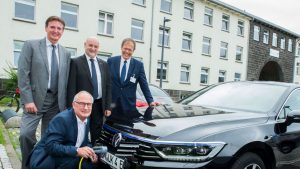 Der Fahrer des Universitätsklinikums Bonn Karl-Heinz Lohmer lädt den neuen Elektro- Dienstwagen des Uniklinikums Bonn. Die Vorstandmitglieder Prof. Wolfgang Holzgreve, Damian Grüttner und Alexander Pröbstl freuen sich