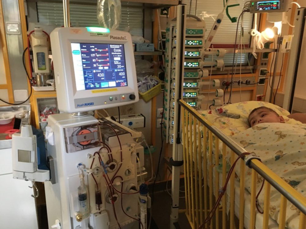 Junger Patient aus dem Kosovo im Krankenbett mit Monitoren