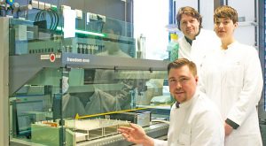 Das Forscherteam am Pipettierroboter in der Abteilung für Genomik des Life & Brain Forschungszentrums: Dr. Andreas Forstner (sitzend vorne), Privatdozent Dr. Rupert Conrad und Psychologin Stefanie Rambau (stehend von links)