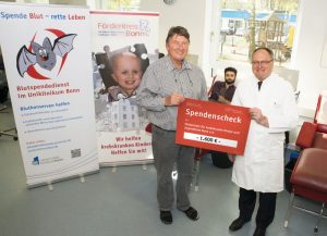 Prof. Oldenburg (re) übergibt Lutz Hennemann einen Scheck in Höhe von 1.600 Euro im laufenden Betrieb des Blutspendedienstes