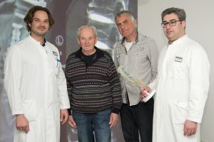 Dr. Cornelius Jacobs (li) und Dr. Koroush Kabir (re) erklären ihren Patienten Rolf S. (2. v. li) und Martin K. (2. V. re) die erfolgreichen Eingriffe anhand von Röntgenbildern und einem dreidimensionalen Wirbelsäulenmodel