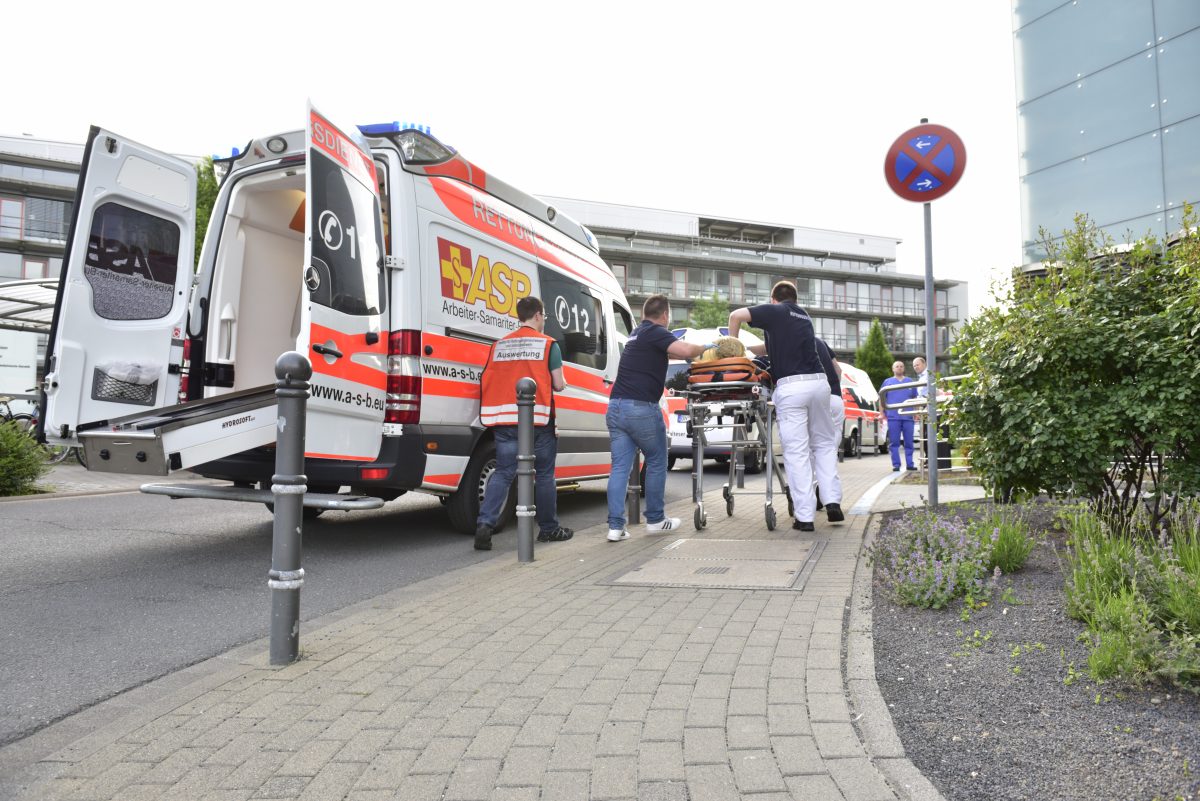 Patient auf Liege neben Rettungswagen