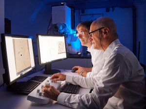 Prof. Fürst und Prof. Lamprecht am neuen Elektronenmikroskop im Pharmazeutischen Institut