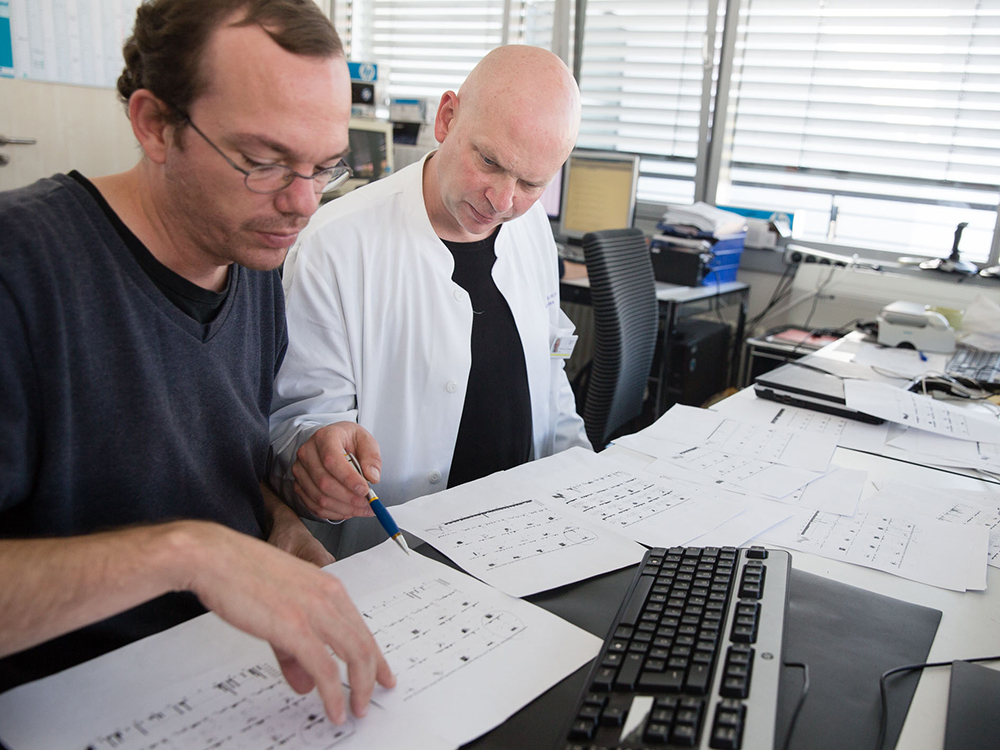 Prof. Dr. Florian Mormann bespricht mit Mitarbeiter (l.) Dr. Thomas Reber (Postdoc seiner Arbeitsgruppe) die Auswertungen vom letzten Patiententest am Computer