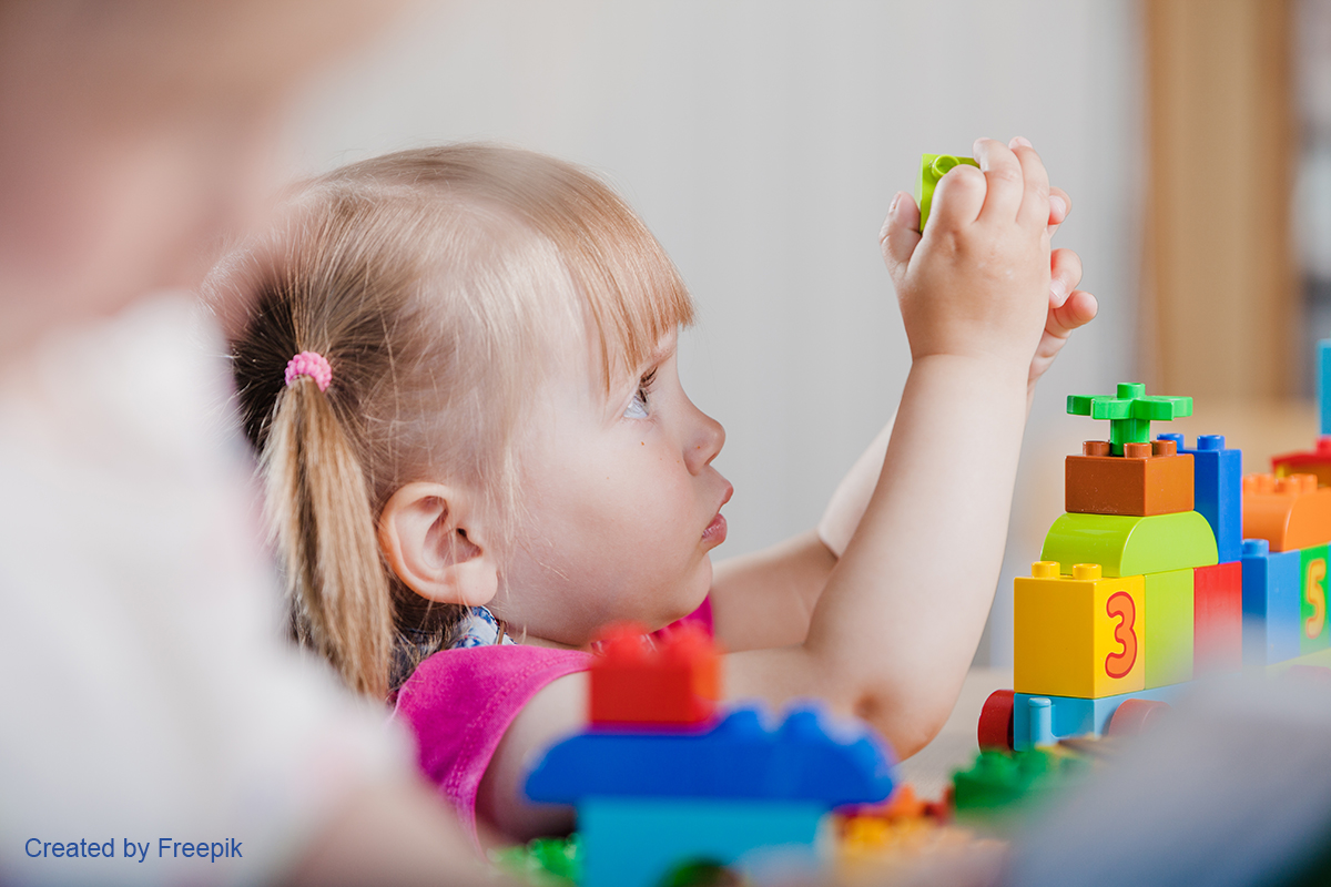 Mädchen spielt mit Duplo