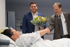 Prof. Wolfgang Holzgreve, Ärztlicher Direktor und Vorstandsvorsitzender am UKB, und Thorsten Trinks, OP-Koordinator am UKB, begrüßen die erste Patientin bei der offiziellen Inbetriebnahme der Patientenholding Area am UKB.
