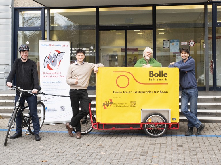 Fledermaus „Cory“ fährt mit Lastenrad durch Bonn