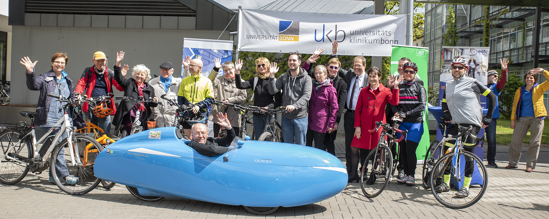 Gruppenbild mit Fahrrädern vor UKB Banner