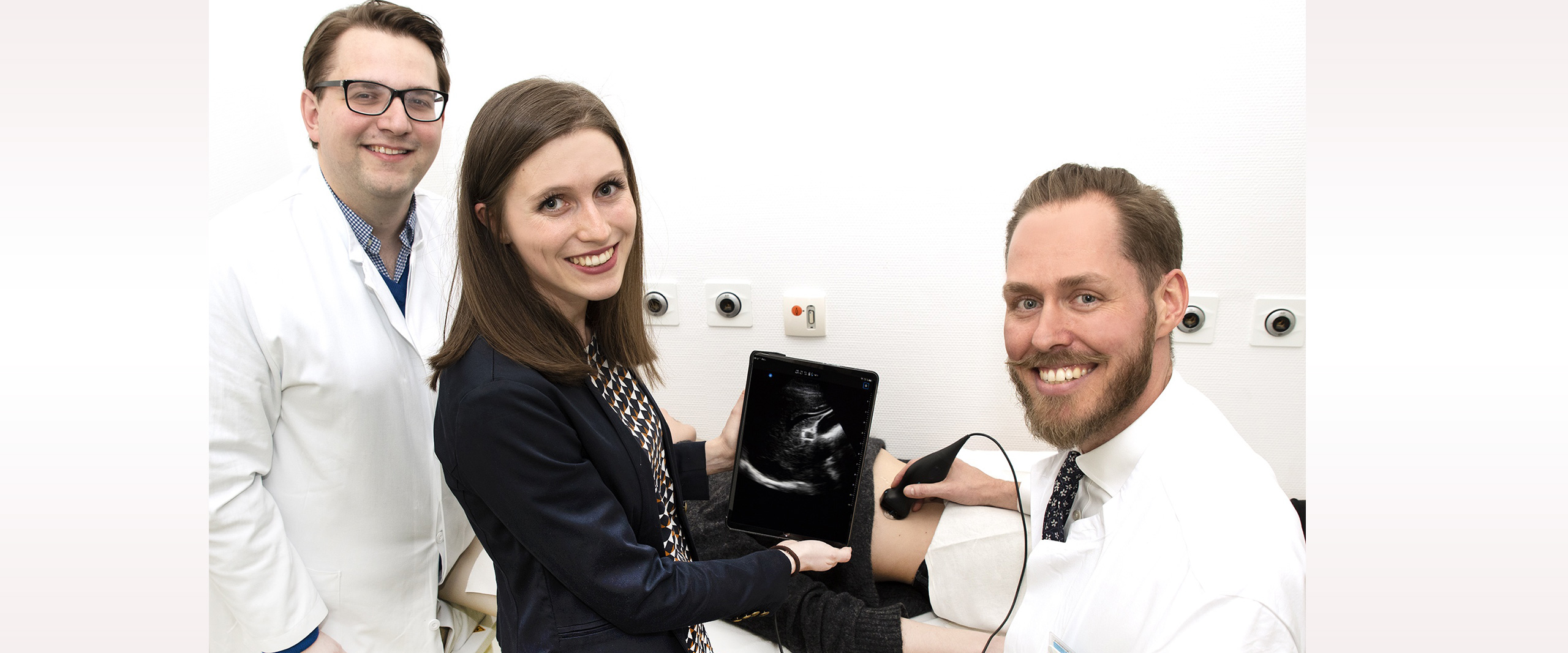 Bonner Medizinische Fakultät etabliert Ultraschallgerät für die Kitteltasche in der Lehre: (v. li.) Dr. Florian Recker, Doktorandin Elena Höhne und Privatdozent Dr. Valentin Schäfer zeigen wie das transportable Ultraschallsystem am Krankenbett eingesetzt werden kann.