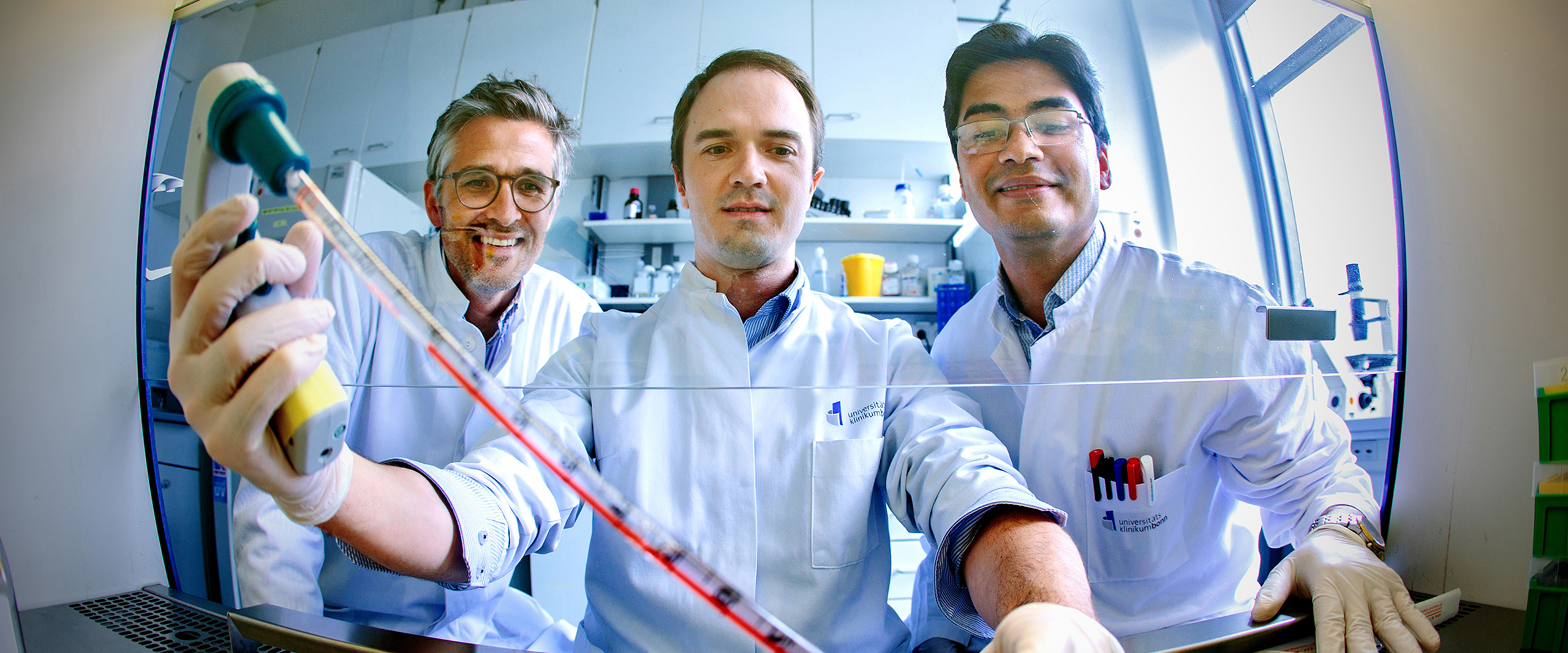 Andreas Zietzer (Mitte), Felix Jansen (links) und Rabiul Hosen (rechts) vom Herzzentrum des Universitätsklinikums Bonn bei der Arbeit an einer sterilen Kulturbank