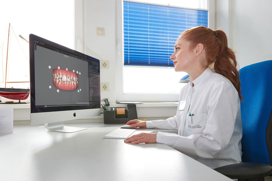 Prof. Anna-Christin Konermann überprüft am Computer eine 3D-simulierte Therapieplanung, den sogenannten "ClinCheck", zur Korrektur der Fehlstellung.