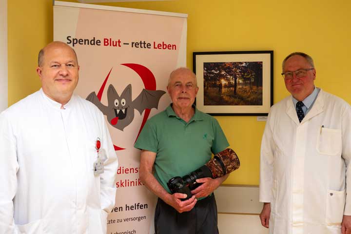 PD Dr. med. Vytautas Ivaskevicius, Oberarzt Institut für Experimentelle Hämatologie und Transfusionsmedizin (IHT), Fotograf Heinrich Pützler und Prof. Dr. Johannes Oldenburg, komm. stellv. Ärztlicher Direktor und Direktor des IHT am UKB, bei der Eröffnung der Ausstellung im Gebäude des Blutspendedienstes am UKB. 