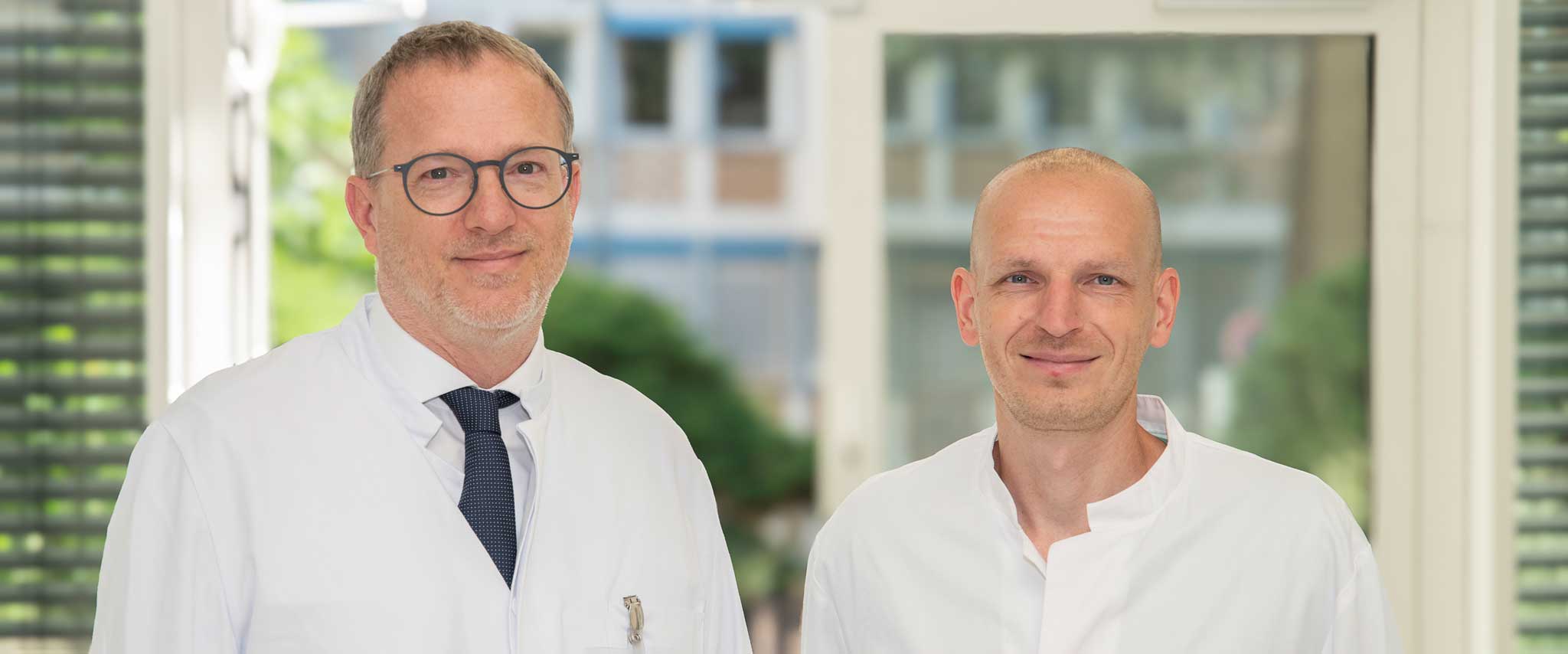 Prof. Dr. Dr. Franz-Josef Kramer, Direktor der Klinik für Mund-, Kiefer- und Plastische Gesichtschirurgie des UKB, und Dr. Tim Klünter, Oberarzt und Sektionsleiter Oralchirurgie, informieren im Patientenkolloquium über Ursachen, Risiken und moderne Behandlungswege bei entzündeten Zahnimplantaten.