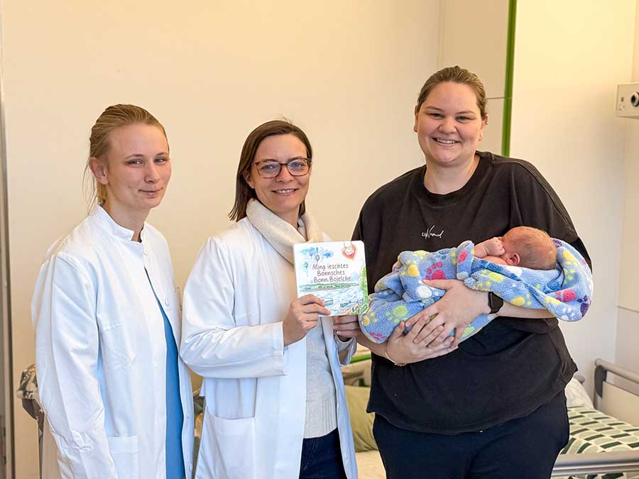 Larissa Kunoff und Prof. Brigitte Strizek überreichten heute das Bilderbuch „Ming ieschtes Bönnsches Bonn Böjelche“ an Michaela Baum und ihr Söhnchen Robin.