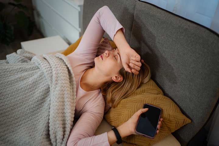 Frau mit Handy im Bett