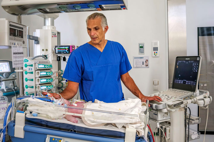Prof. Sabir untersucht ein Neugeborenes mittels Ultraschall. Die frühzeitige Diagnostik und eine spezialisierte Behandlung sind entscheidend für die Versorgung von Kindern, die rund um die Geburt einen Sauerstoffmangel erlitten haben.